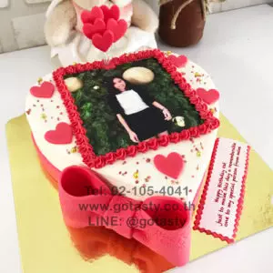 Red and white cream photo cake with heart and bow decorations