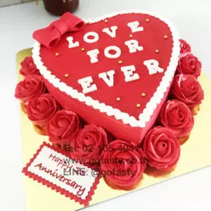 Red cream cake with rose and bow decorations